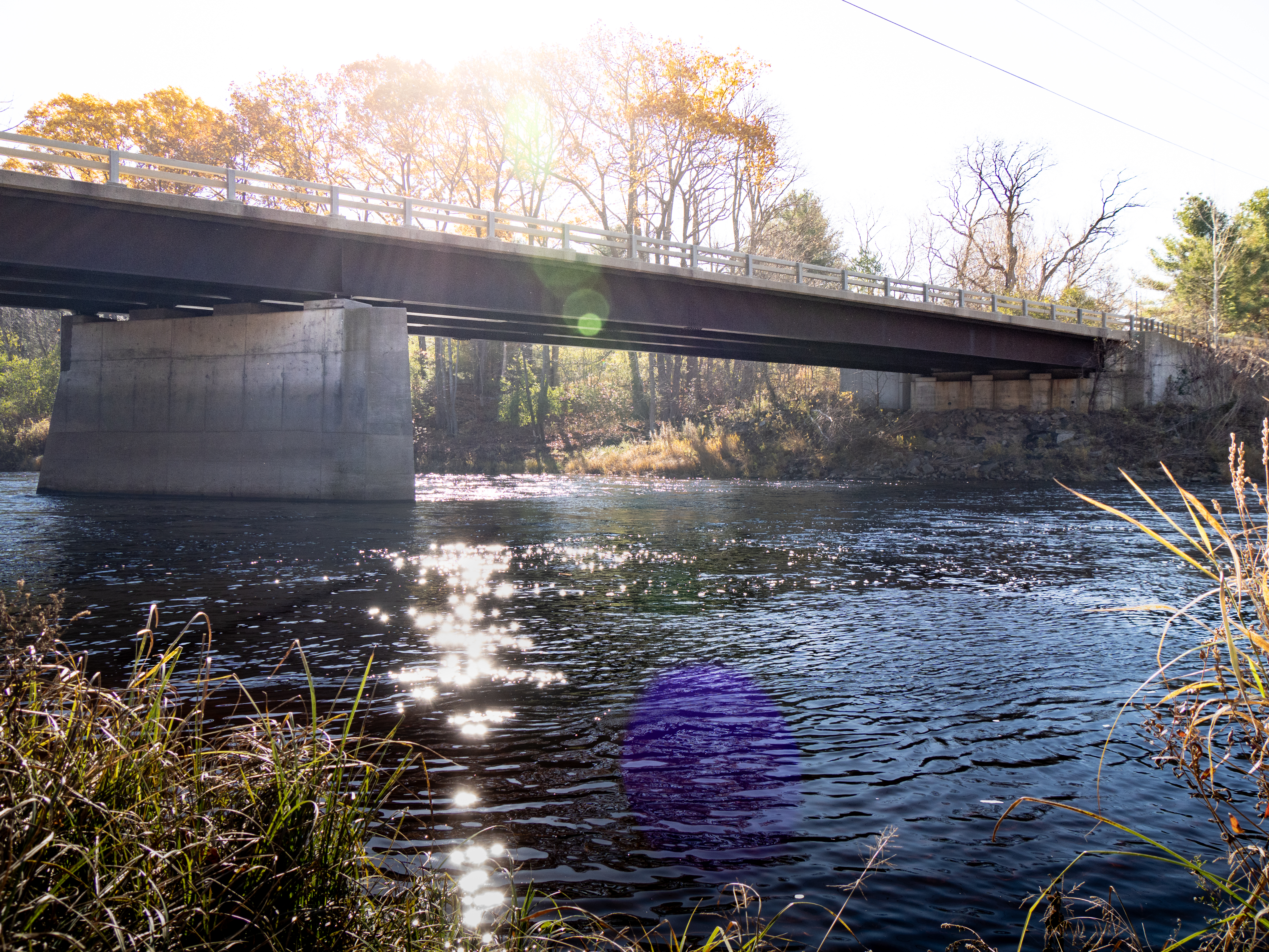 A scenic view of a bridge spanning over the St. Regis River.