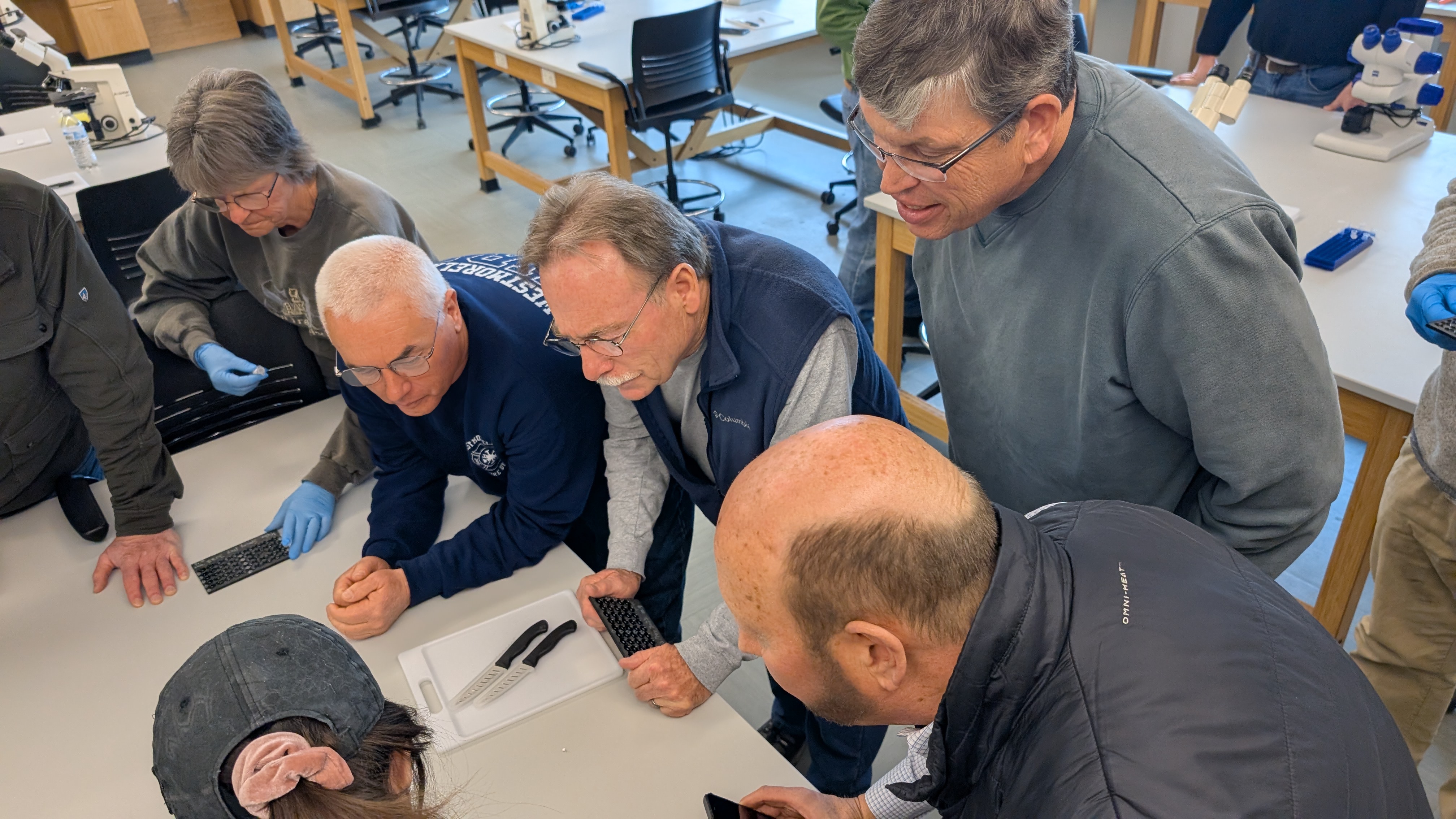 Team of elderly researchers and anglers collaborating on topographical data.